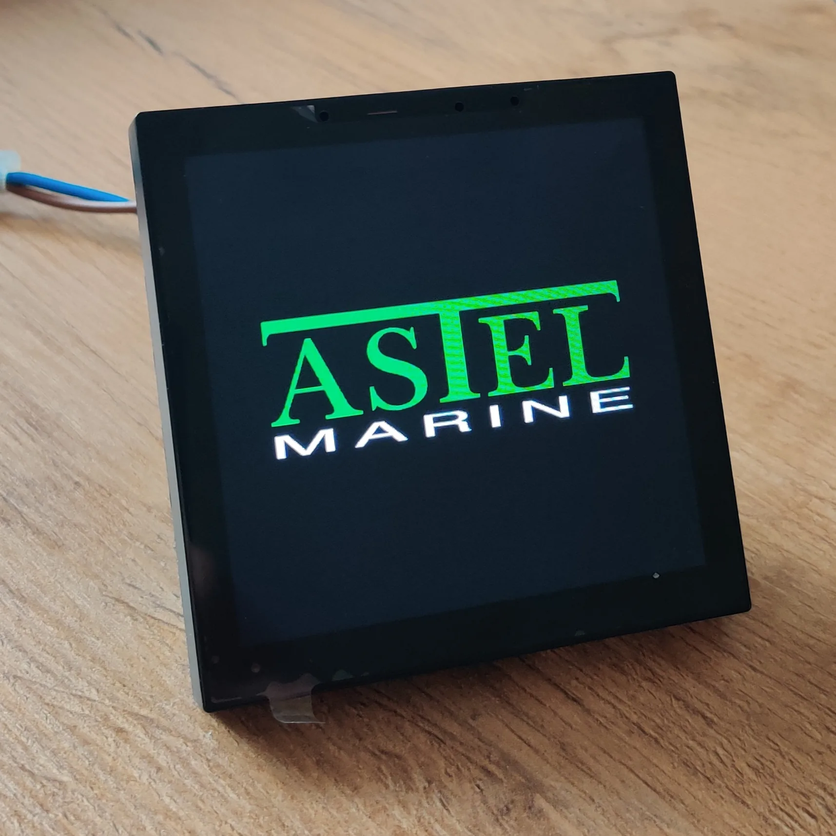 Kiosk z zaslonom na dotik, na katerem je prikazan zagonski logotip ASTEL Marine